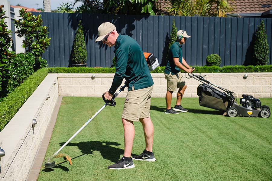 The Lawn Busters team mowing and edging an Adelaide lawn